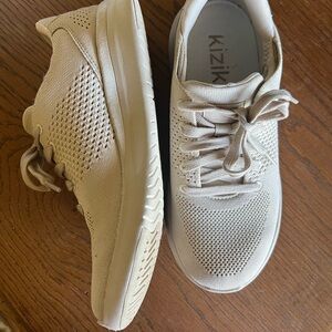 Kizik beige slip on tennis shoes.